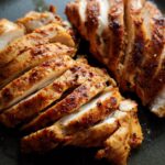 Close-up of perfectly cooked, sliced air fryer chicken breast with a golden-brown, seasoned crust.