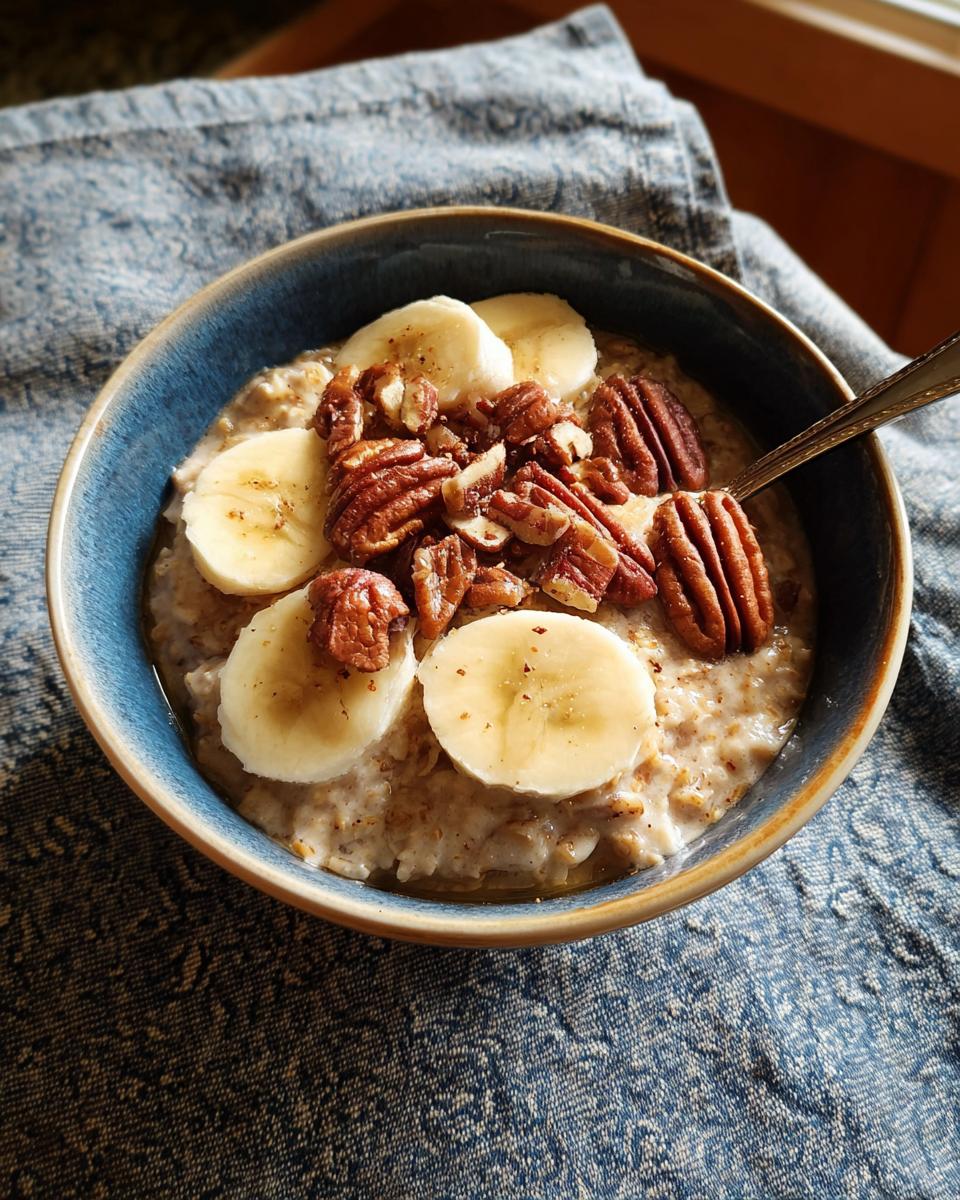 A bowl of oatmeal topped with banana slices and pecans, a perfect example of one of our 12 genius breakfast ideas.