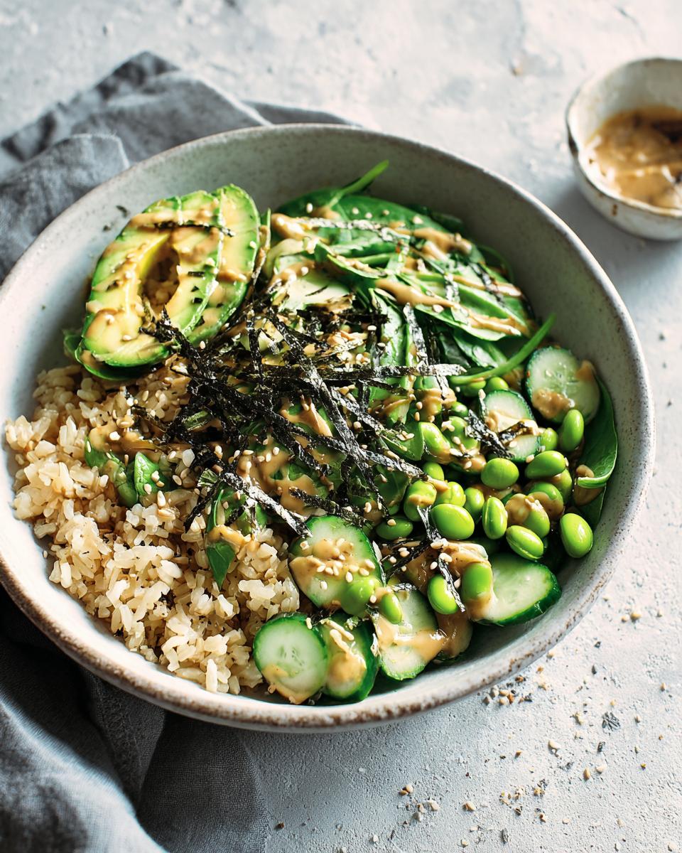 A delicious and healthy rice bowl for beginners, featuring brown rice, avocado, edamame, cucumber, spinach, and a creamy dressing.