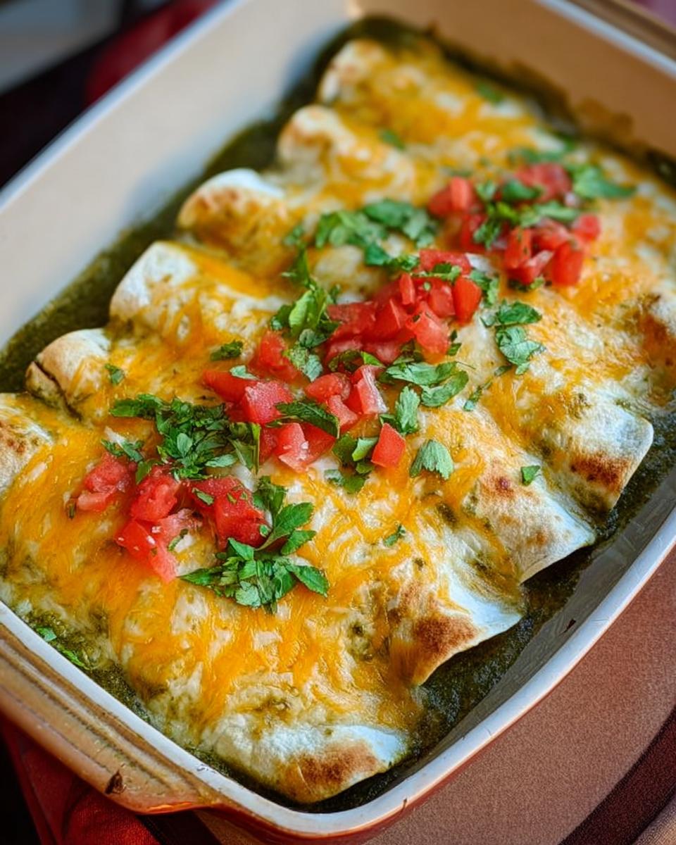 A baking dish filled with cheesy chicken enchiladas topped with salsa verde and fresh cilantro.