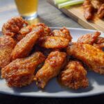A plate full of crispy, saucy chicken wings, perfect for satisfying chicken wing cravings.