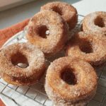Six freshly baked cinnamon sugar donuts on a cooling rack, perfect for breakfast ideas recipes.