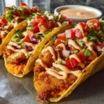 Three crispy fish tacos loaded with fresh toppings and a creamy sauce, perfect for Taco Tuesday recipes.