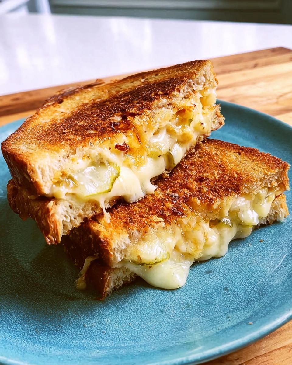 A close-up of a perfectly grilled cheese sandwich, cut in half, with melted cheese oozing out.