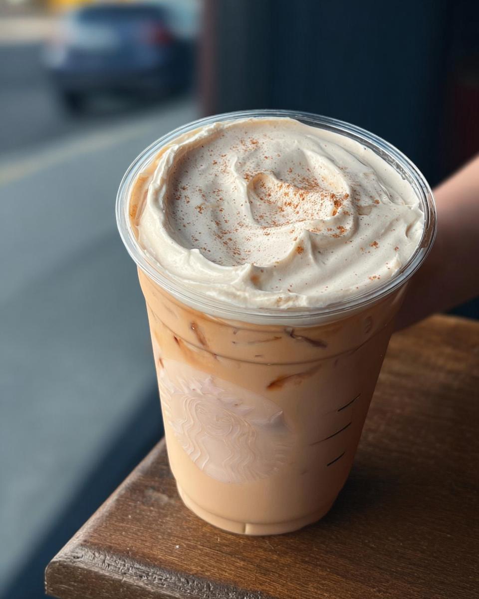 Close-up of an iced coffee drink with whipped cream and cinnamon, a Starbucks drink recipe at home.