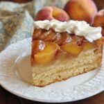 A slice of peach upside down cake topped with whipped cream, part of The Ultimate Cake Ideas Recipes Guide for Beginners.