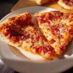 Two slices of delicious pizza, perfect for Pizza Night Recipes Meal Prep, on a plate with melted cheese and tomato sauce.