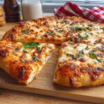 A delicious restaurant-style pizza, topped with melted cheese and fresh basil, ready for pizza night at home.