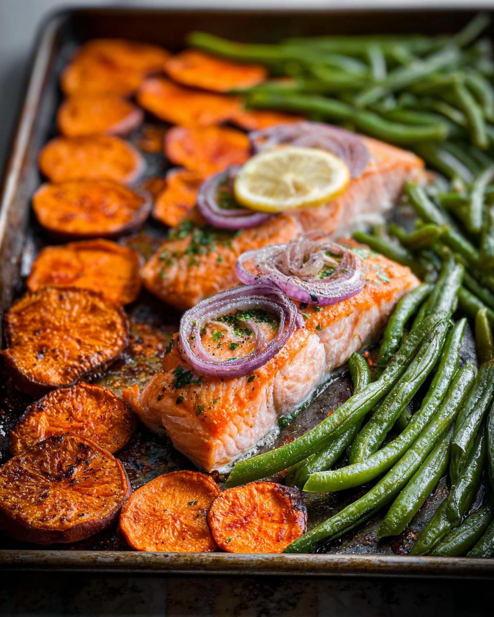 Close-up of a sheet pan with perfectly cooked salmon fillets, roasted sweet potato slices, and vibrant green beans, ideal for salmon recipes meal prep.