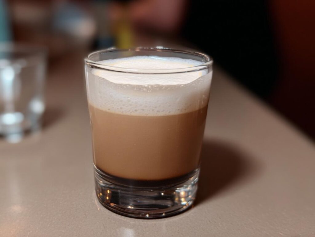 A layered Starbucks drink with foamy milk on top in a clear glass, perfect for busy weeknights.