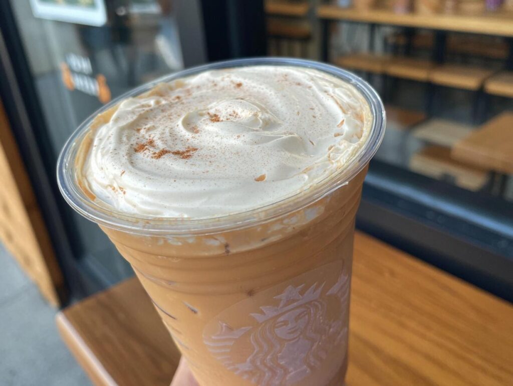 Close-up of a Starbucks drink with whipped cream and cinnamon, representing Starbucks drinks recipes at home.