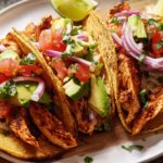 Three fully loaded chicken tacos with avocado, tomato, red onion, and cilantro, perfect for Taco Tuesday Recipes Meal Prep.