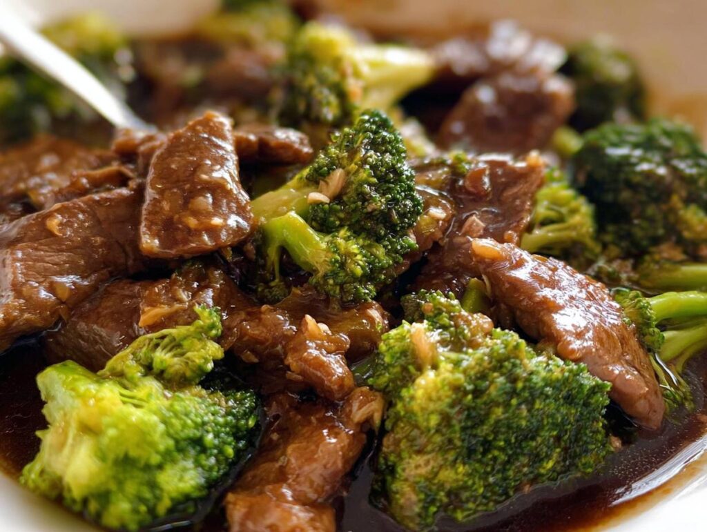 Close-up of tender slices of Chinese Beef and Broccoli coated in a glossy brown sauce.