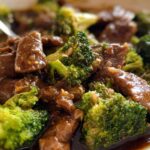 Close-up of tender slices of Chinese Beef and Broccoli coated in a glossy brown sauce.