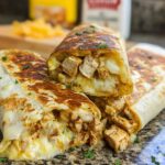 Close-up of Cozy Cheesy Garlic Chicken Wraps, showing tender chicken and melted cheese spilling out.