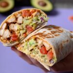 A halved Easy Chipotle Ranch Grilled Chicken Burrito showing grilled chicken, avocado, tomato, lettuce, and chipotle ranch sauce.