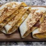Close-up of golden-brown High-Protein Chicken Ranch Quesadilla slices filled with melted cheese and chicken.
