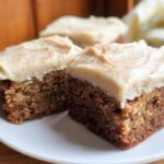Close-up of three slices of Banana Bread Brownies Made Easy, topped with creamy frosting and a sprinkle of cinnamon.