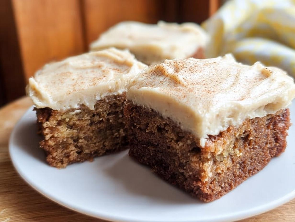 Close-up of three slices of Banana Bread Brownies Made Easy, topped with creamy frosting and a sprinkle of cinnamon.