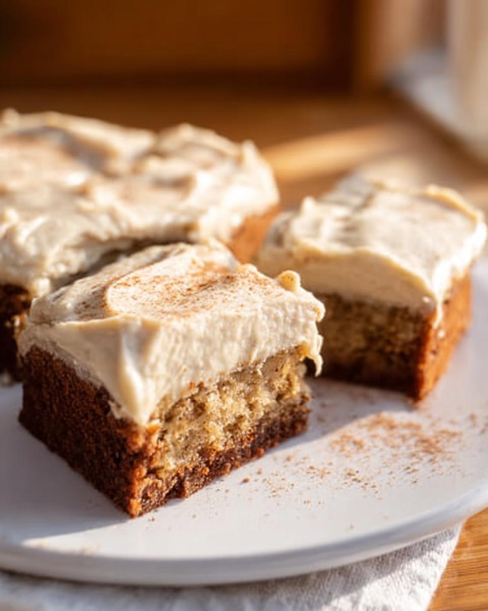 Three slices of Banana Bread Brownies Made Easy topped with creamy frosting and a sprinkle of cinnamon.