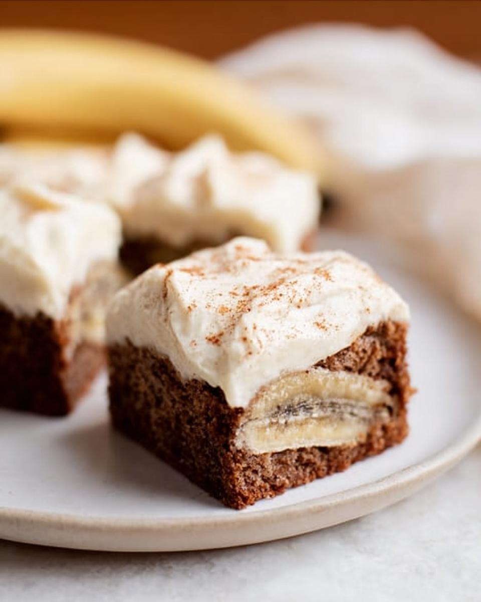 A close-up of an easy Banana Bread Brownie made easy, topped with cream cheese frosting and a sprinkle of cinnamon.