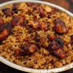 A close-up of a bowl filled with flavorful BBQ chicken and rice, featuring tender chicken pieces coated in a rich sauce.