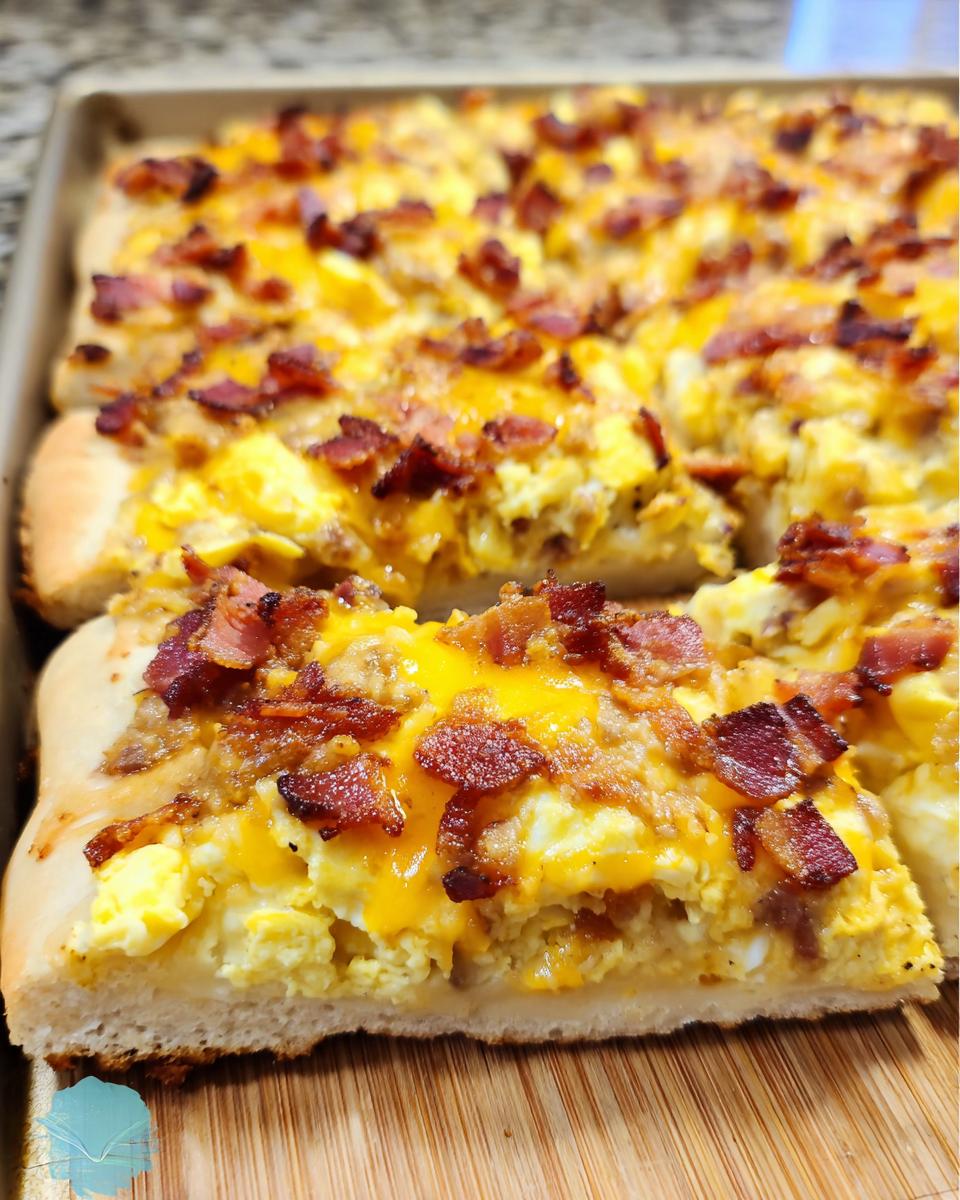 A close-up of a slice of breakfast pizza with scrambled eggs, melted cheese, and crispy bacon.