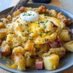A delicious Cheesy Potato Egg Scramble topped with a dollop of sour cream and chives.