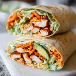 A delicious wrap filled with creamy spinach and eggs, chicken, avocado, and shredded carrots.