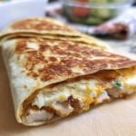 A delicious Crispy Chicken Bacon Wrap, grilled to golden perfection, with visible chicken and melted cheese.