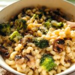 A bowl of Healthy One Pot Broccoli Mac & Cheese with pasta, broccoli florets, and mushrooms.