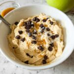 A bowl of Greek Yogurt Cookie Dough topped with chocolate chips and a caramel drizzle.