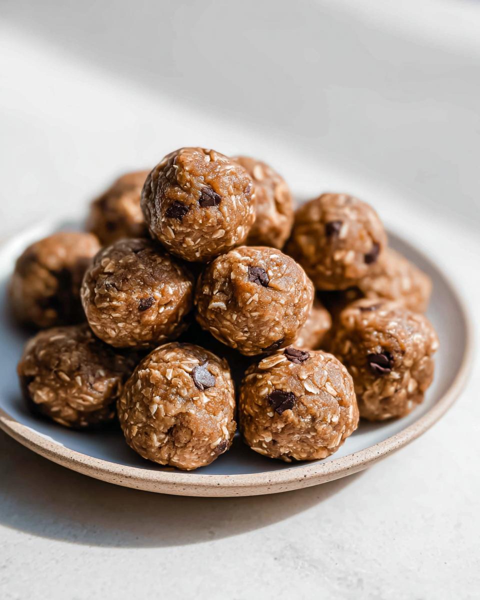A pile of no-bake chocolate peanut butter protein balls with visible chocolate chips and oats.