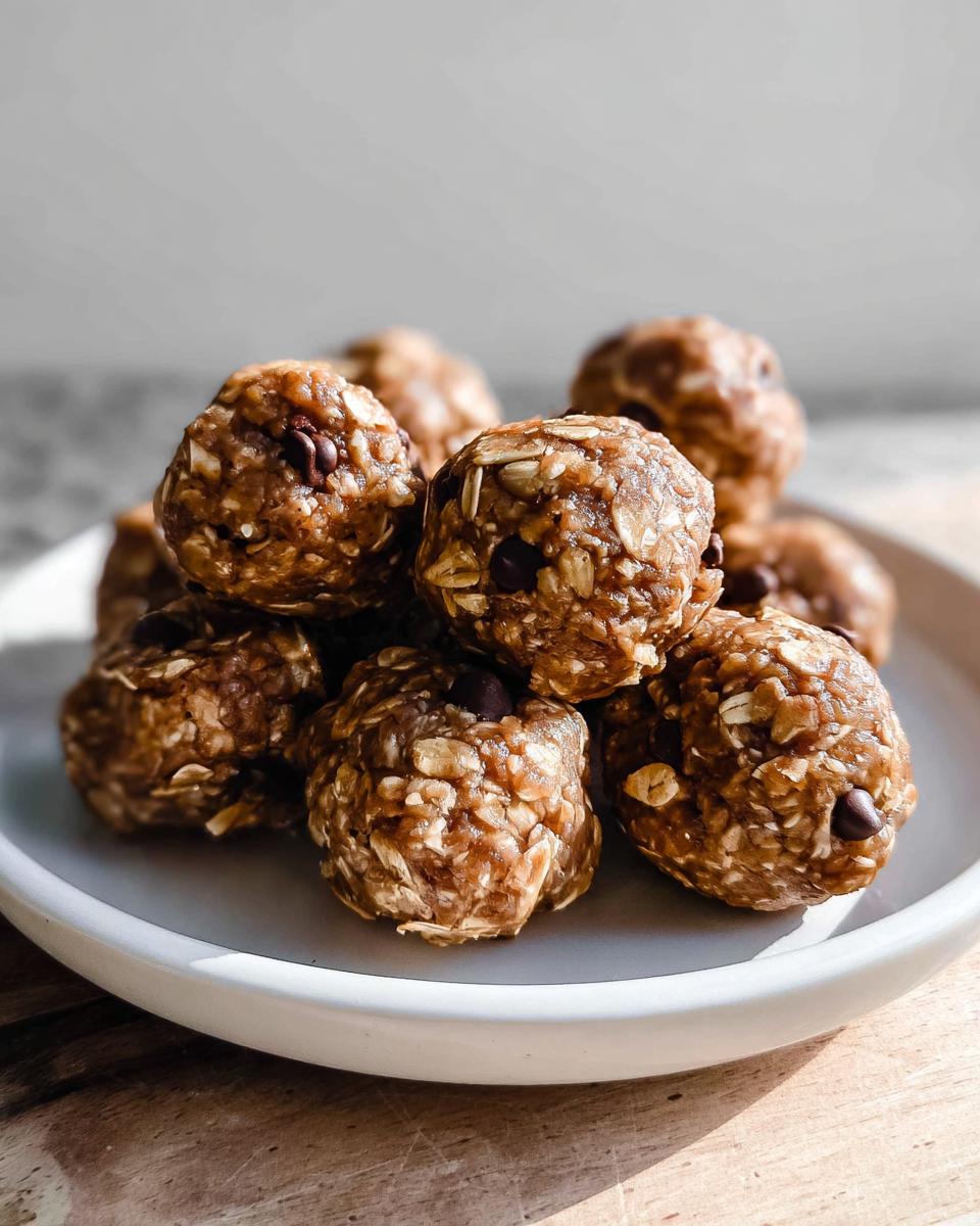 A stack of delicious no-bake chocolate peanut butter protein balls with visible oats and chocolate chips.