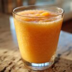 A refreshing glass of peach iced tea slush, perfect for hot afternoons.