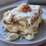 A slice of no-bake Raffaello Tiramisu schnell ohne Backen, layered with ladyfingers, cream, and coconut.