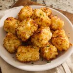 A white bowl filled with golden brown, crispy Two Ingredient Cottage Cheese Tots, sprinkled with parsley.